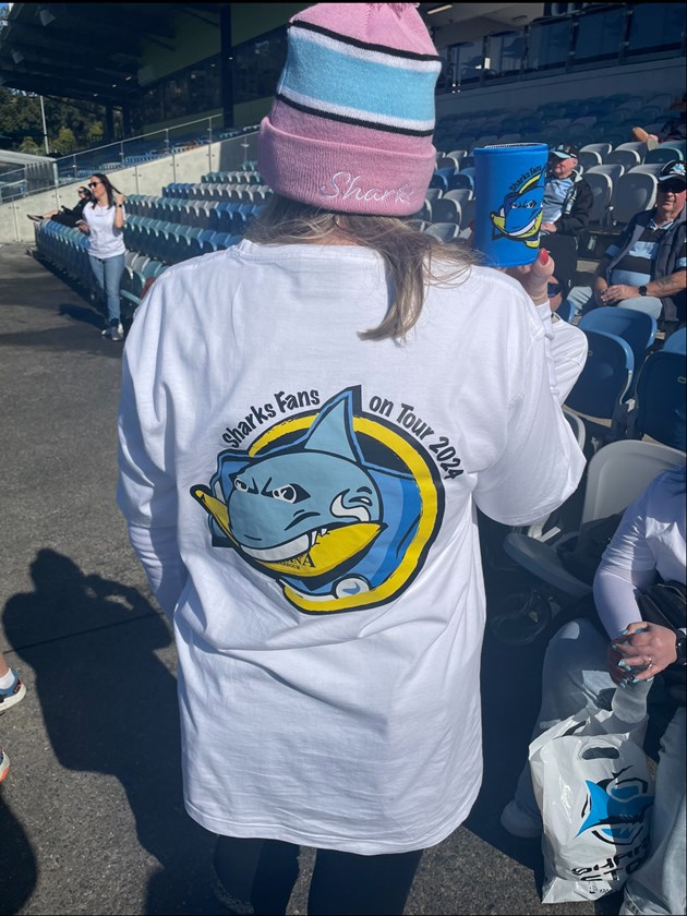 Trish Metti shows off her custom 'Sharks on Tour' shirt and stubby holder.